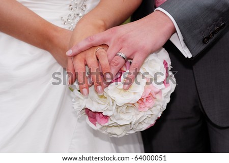 Newlywed couple holding hands with bouquet. Converted from RAW with minimal sharpening.