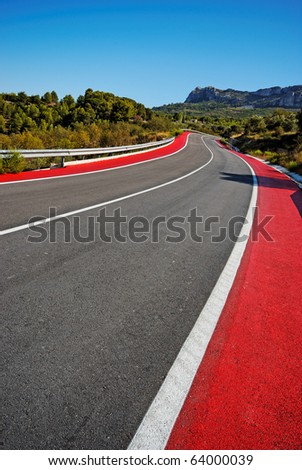 Winding Road and Red Cycle Lane through mountains. Road from Benidorm to Guadalest. Clear blue sky. Converted from RAW