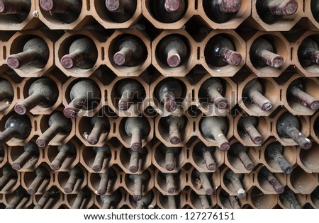 Italy, Sicily, old red wine bottles aging in a wine cellar