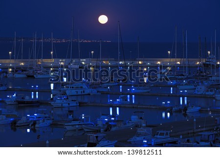 Italy, Sicily, Mediterranean sea, Marina di Ragusa, view of luxury yachts in the marina at night with full moon