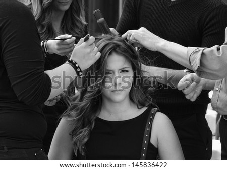 Italy, Sicily, young girl having her hair combed by hairdressers