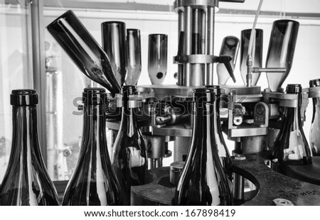 Italy, Sicily, wine bottles being washed and filled with wine by an industrial machine in a wine factory