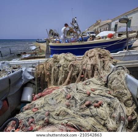 Italy, Sicily, Mediterranean sea, Sampieri (Ragusa Province), fisherman working ashore on his fishing boat