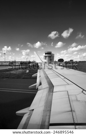 Italy, airplane wing and flight control tower in an airport