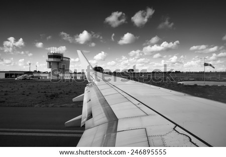 Italy, airplane wing and flight control tower in an airport
