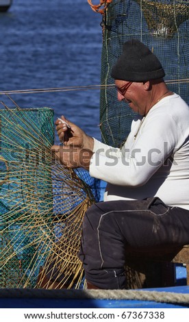 Italy, Sicily, Portopalo di Capo Passero, a fisherman making a lobster pot