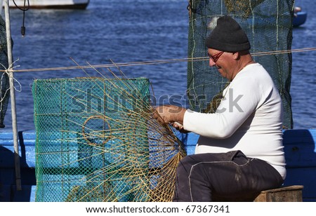 Italy, Sicily, Portopalo di Capo Passero, a fisherman making a lobster pot