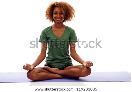 Pretty smiling young black woman doing yoga exercise on mat isolated over white