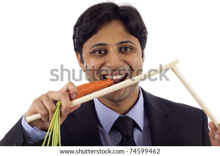 stock-photo-business-concept-rewards-and-punishment-young-indian-business-man-eating-a-carrot-and-breaking-74599462.jpg