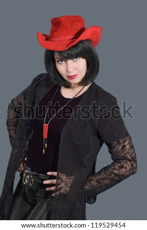 Portrait of pretty woman with red hat on her head isolated on grey