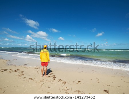 Young man  life saver  watching the situation on the sea.Wide angle