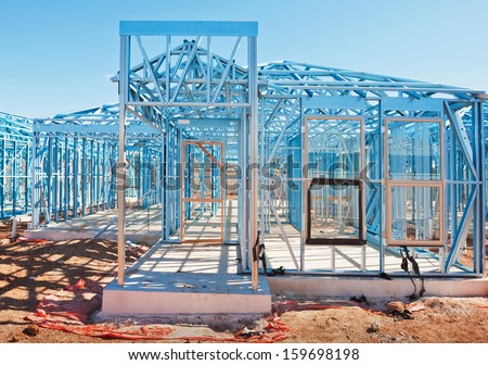 New residential construction home metal framing against a blue sky