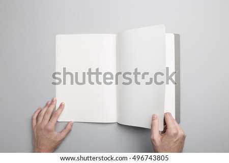 Hands holding opened Notebook. Blank paper Mock-up.
