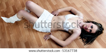 She\'s lies on timber floor already (Young woman in white lingerie and white boots on timber floor)