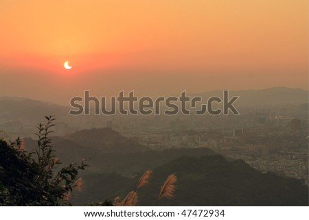 solar eclipse with city and mountain view