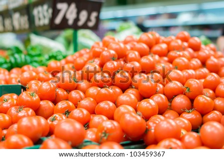 Variety of tomatoes in black boxes in supermarket