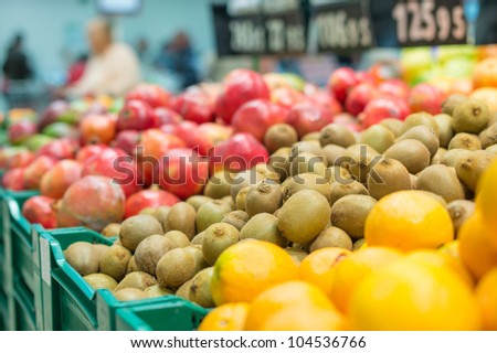 Variety of kiwi fruits and pomegranate fruits in boxes in supermarket