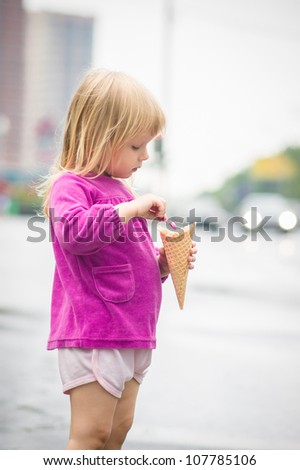 Adorable girl eat ice cream on bus stop