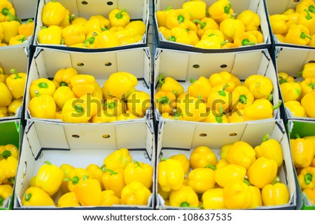 Bunch of yellow paprika in boxes in supermarket
