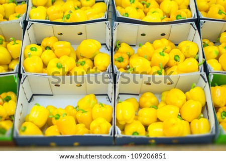 Bunch of yellow paprika in boxes in supermarket