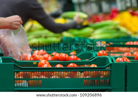Bunch of tomatoes in plastic boxes in supermarket