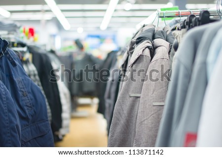 Variety of jackets, vests and sweaters on stands in supermarket