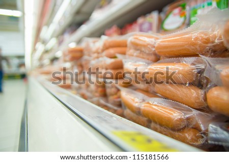 Variety of packed sausages in fridge in supermarket
