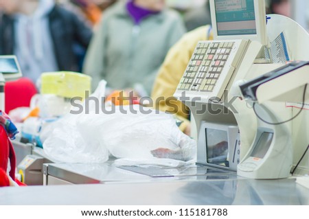 Cash-desk with cashier and terminal in supermarket. Serve customer