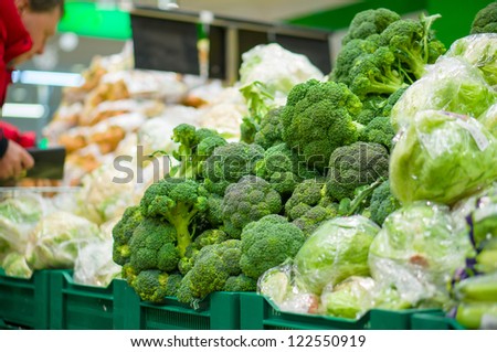 Bunch of broccoli, cabbage and salad on boxes in supermarket