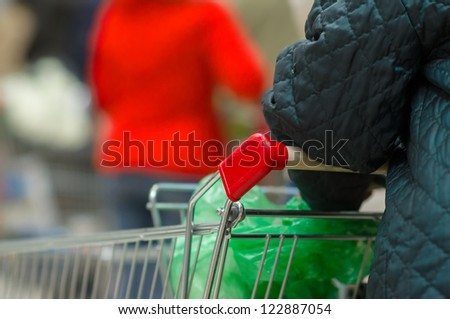 Customers with baskets and carts in queue in supermarket