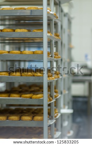 Shelves with baked donuts in fast food restaurant in huge store