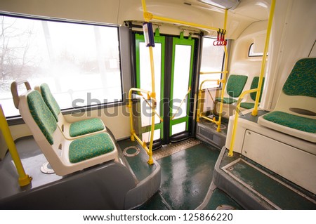 Interior of modern city bus. Seat places and door in back side of bus. Wide angle shot