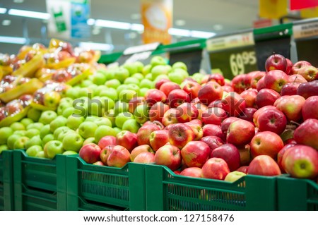Bunch of red and green apples on boxes in supermarket