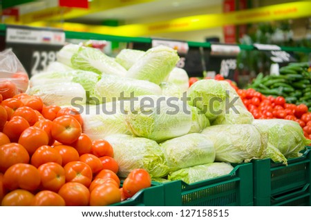 Bunch of chinese cabbages and tomatoes on boxes in supermarket