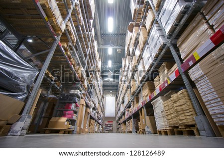 Rows Of Shelves With Cardboard Boxes On Modern Warehouse In Store