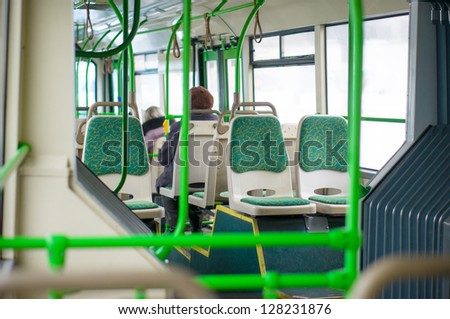 Interior of modern articulated bus. Seat places in front side of bus. Shoot through articulated joint part
