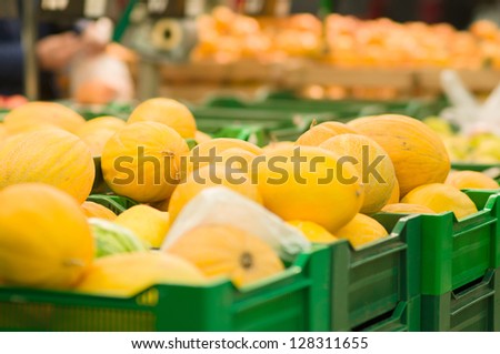 Bunch of melons on boxes in supermarket