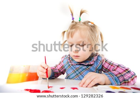 Adorable baby draw with color paints on paper sheet sitting