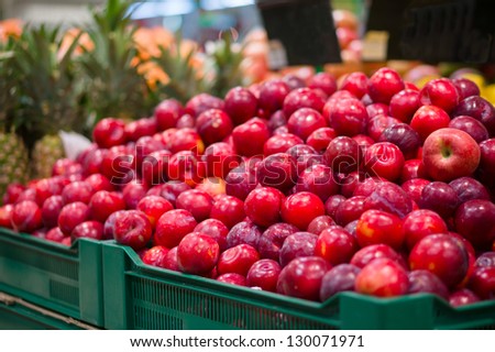Bunch of plums on boxes in supermarket