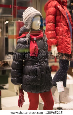 Mannequins in winter sweaters, jackets, scarfs and hats in store
