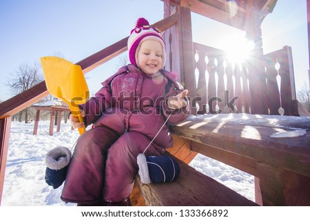 Adorable girl sit on stairs on wooden slide for kids on playground
