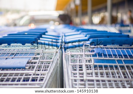 Rows of blue shopping carts on entrance of supermarket