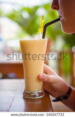 Woman drink shake on table in beach restaurant