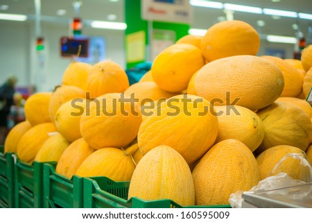 Bunch of yellow melons on boxes in supermarket
