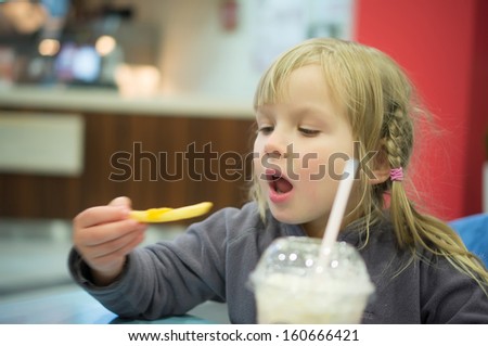 Adorable girl have meal in fast food restaurant - stock-photo-adorable-girl-have-meal-in-fast-food-restaurant-160666421