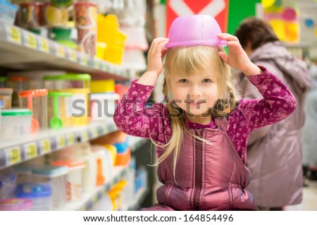 Adorable Girl Play With Plastic Containers On Head In Supermarket