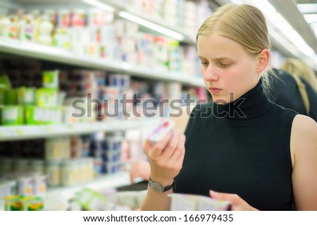 Young woman select milk products in supermarket