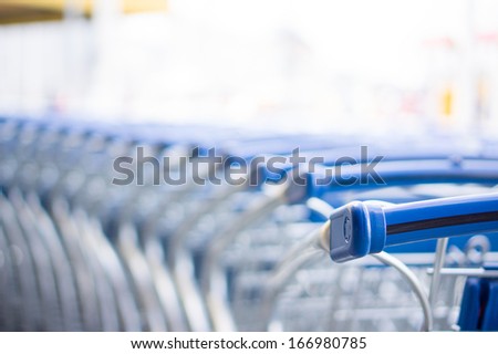 Bunch of empty blue shopping cart at supermarket entrance