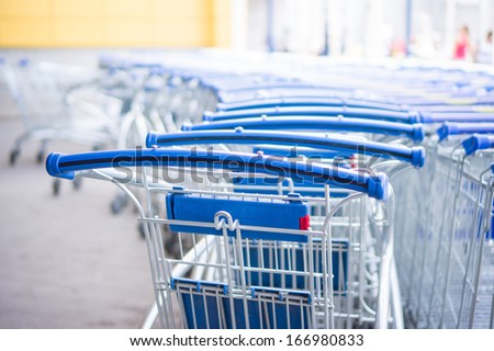 Bunch of empty blue shopping cart at supermarket entrance