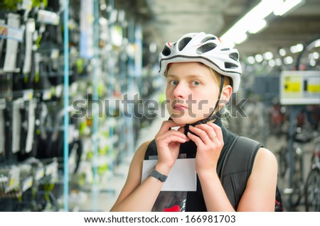 Young woman fitting bike helmet in sport store